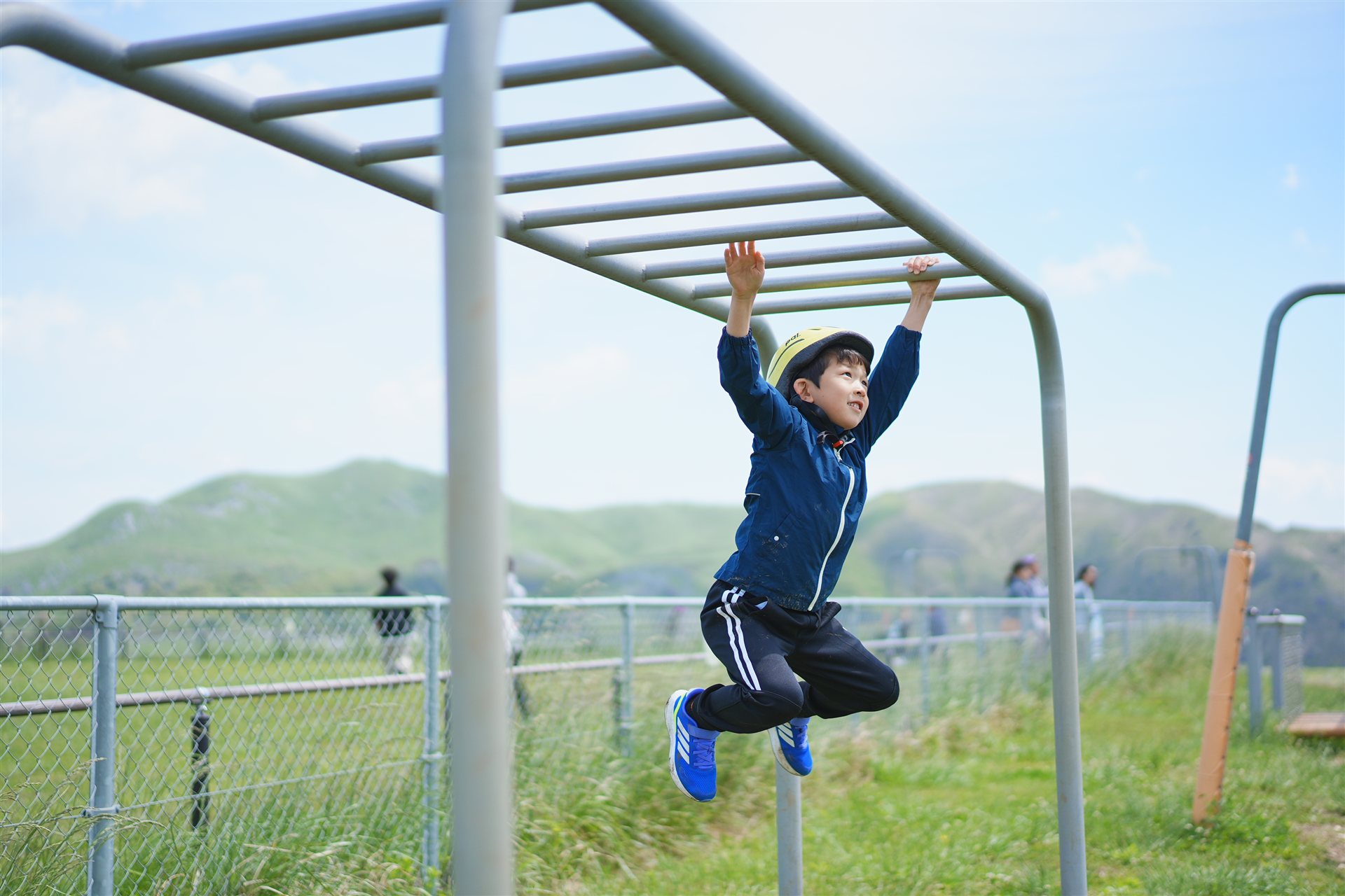 雲梯にぶら下がる子ども